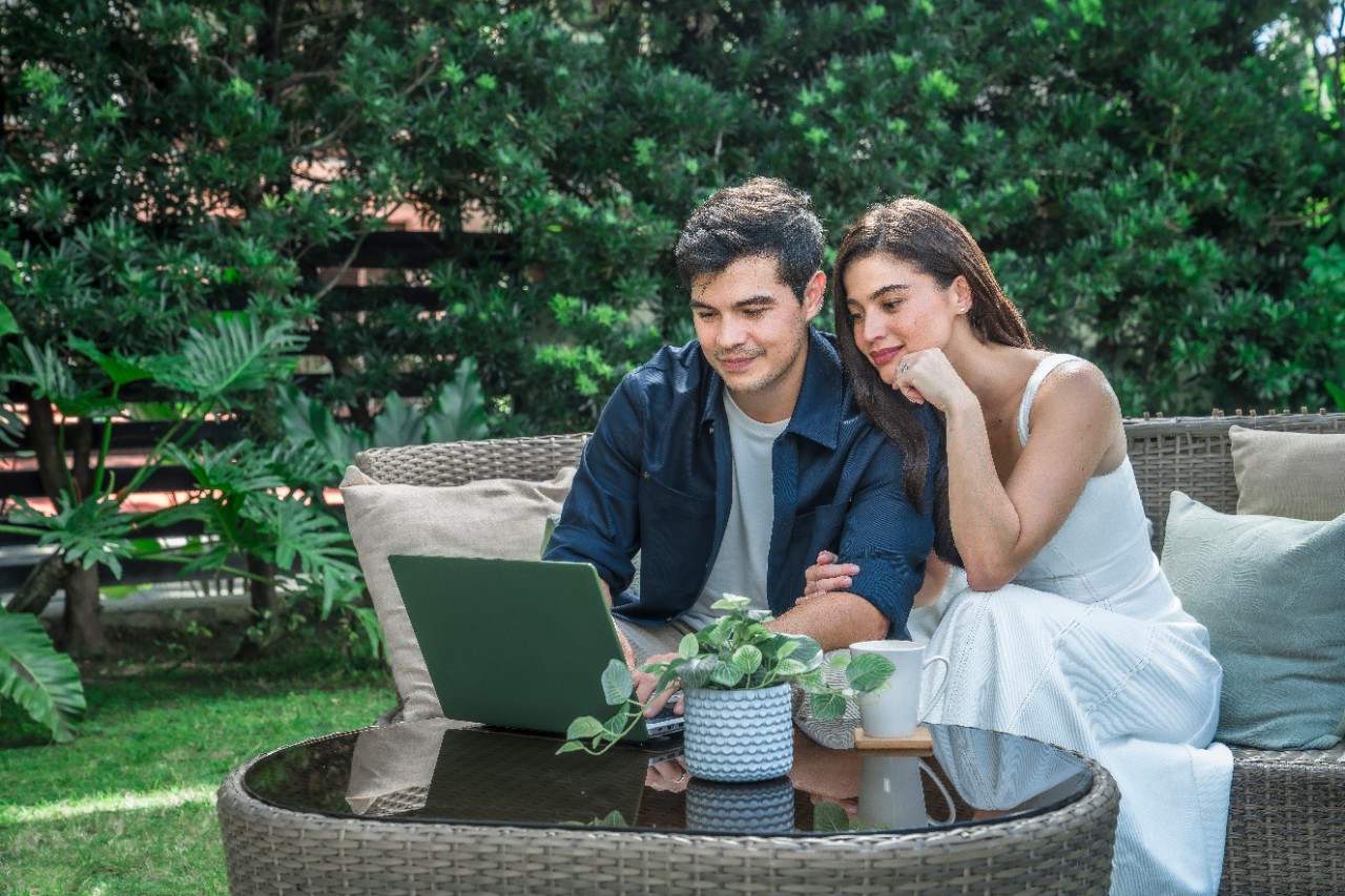 couple in the garden looking at a laptop